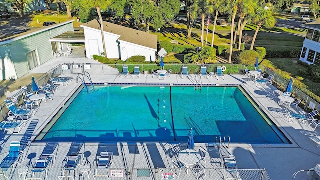 community pool with fence and a patio