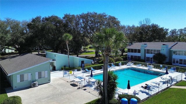 community pool with fence and a patio area
