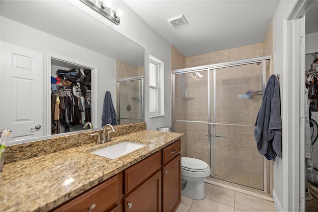 6306 Pecan Crse, Ocala, FL 34472 - bathroom with a shower stall, tile patterned flooring, vanity, a walk in closet, and toilet