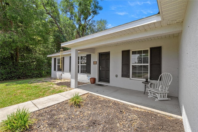 6306 Pecan Crse, Ocala, FL 34472 - entrance to property featuring stucco siding, covered porch, and a yard
