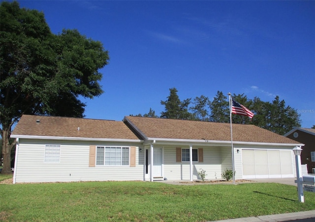 single story home featuring an attached garage, roof with shingles, a front yard, and concrete driveway
