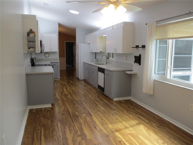kitchen with light countertops, wood finished floors, white cabinets, and white appliances