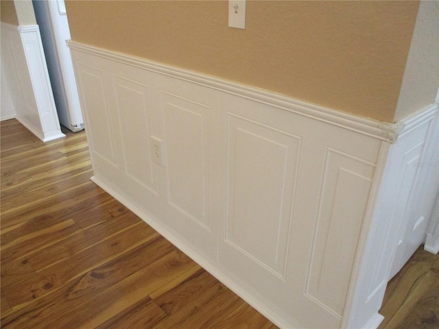 room details with a wainscoted wall, wood finished floors, and a decorative wall