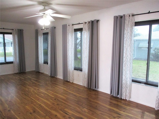 spare room with plenty of natural light, a ceiling fan, and wood finished floors
