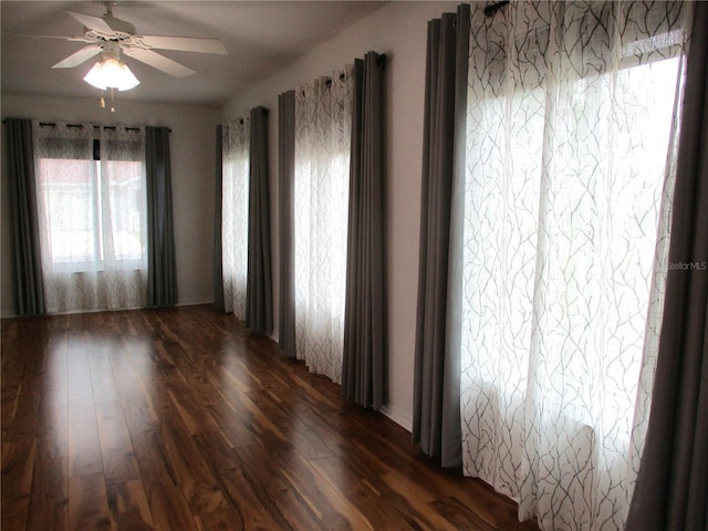empty room with dark wood finished floors and ceiling fan