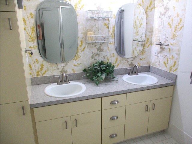 full bath with double vanity, wallpapered walls, and a sink