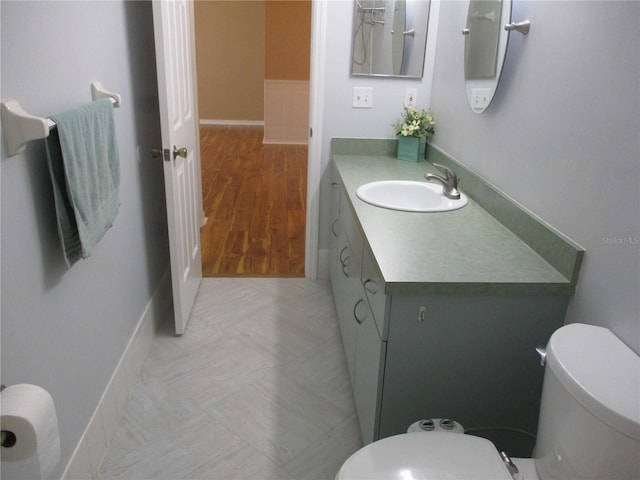 bathroom with vanity, baseboards, and toilet