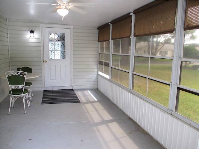 unfurnished sunroom featuring ceiling fan