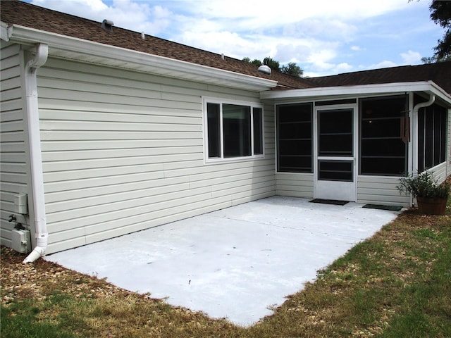 rear view of property featuring a sunroom and a patio