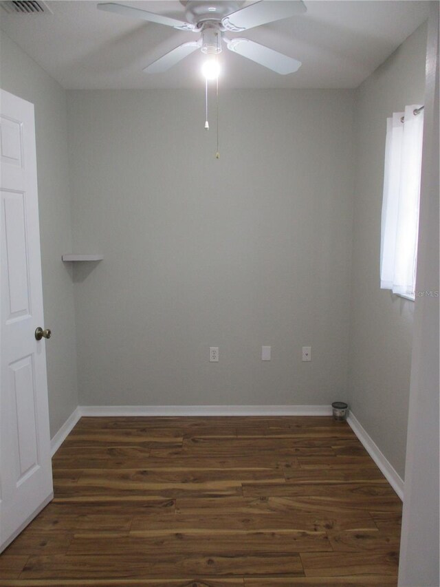 unfurnished room featuring a ceiling fan, baseboards, visible vents, and dark wood-type flooring