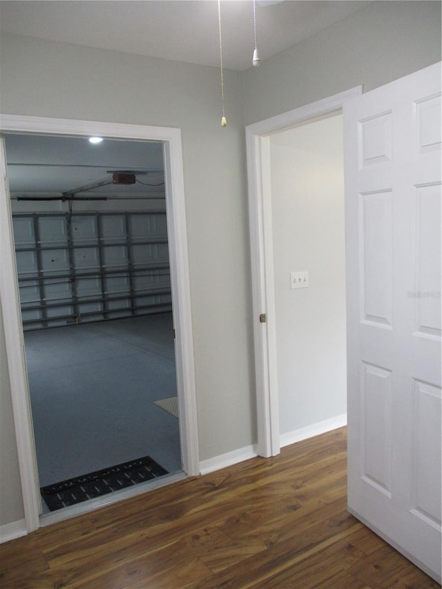 corridor featuring baseboards, wood finished floors, and visible vents