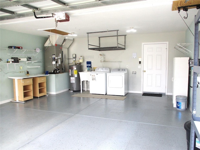 garage with baseboards, heating unit, independent washer and dryer, and electric water heater