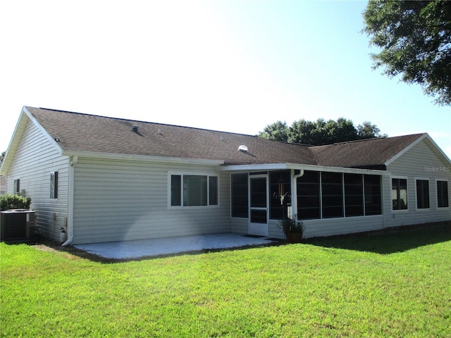 rear view of house with central air condition unit, a yard, a sunroom, and a patio area