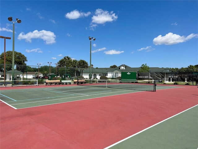 view of tennis court featuring fence and community basketball court
