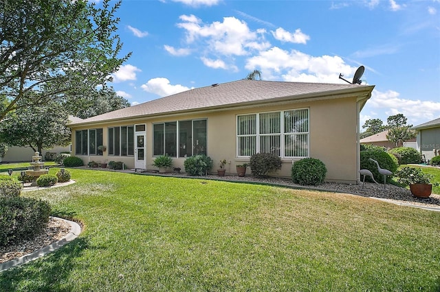 rear view of property featuring stucco siding and a yard