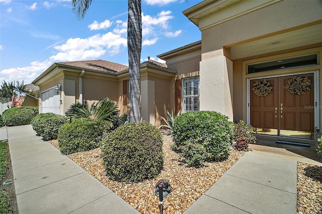 exterior space featuring an attached garage and stucco siding