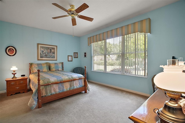 carpeted bedroom featuring baseboards and a ceiling fan