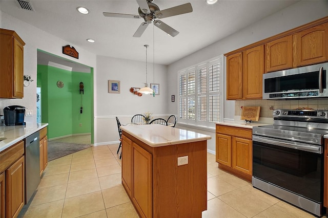 kitchen with visible vents, ceiling fan, a center island, light countertops, and appliances with stainless steel finishes