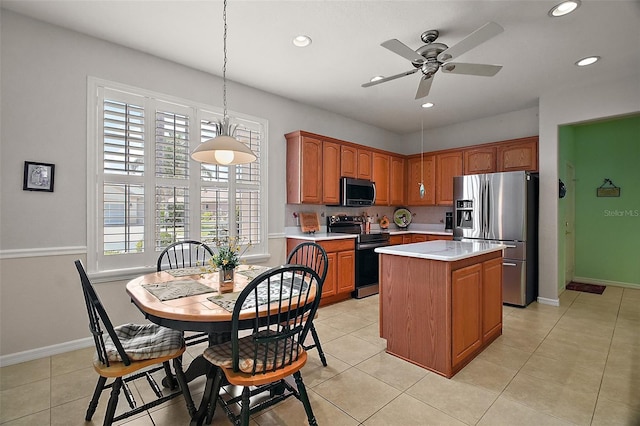 kitchen with ceiling fan, appliances with stainless steel finishes, light countertops, recessed lighting, and a kitchen island