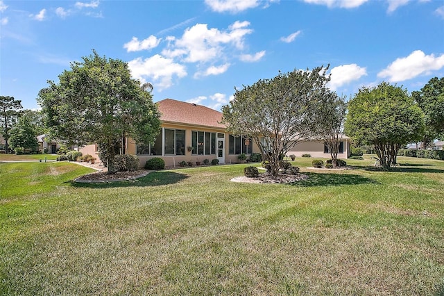 rear view of property featuring a lawn