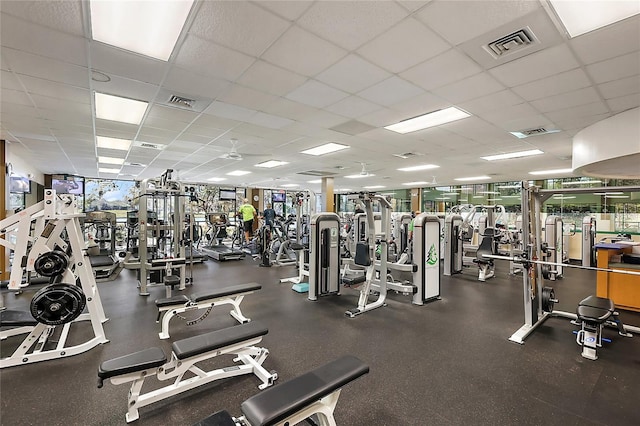 exercise room with visible vents and a paneled ceiling