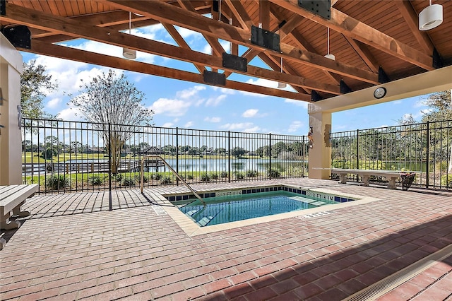 view of pool featuring fence, a gazebo, and a water view