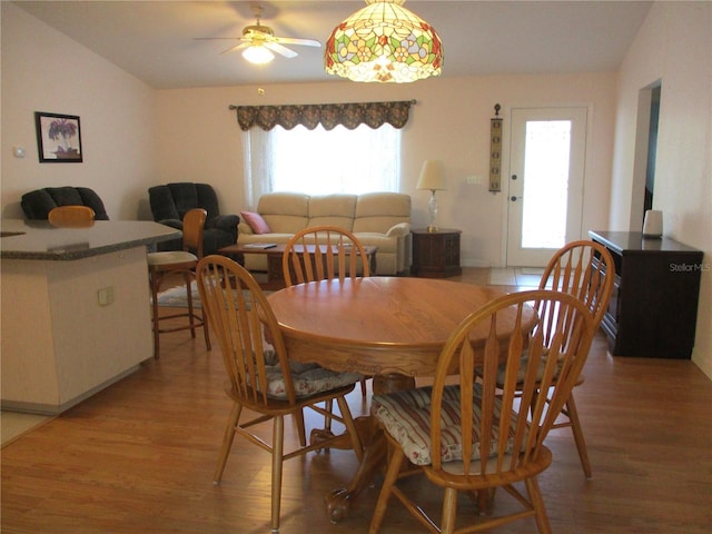 dining room featuring light wood-style floors, ceiling fan, and lofted ceiling