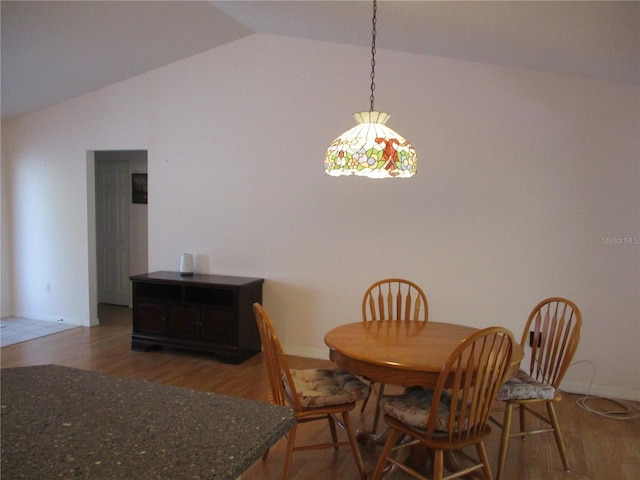 dining area featuring wood finished floors and lofted ceiling