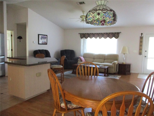 dining room with ceiling fan, visible vents, lofted ceiling, and light wood-type flooring