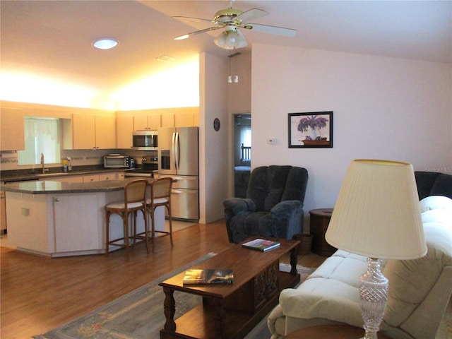 living area featuring light wood-style floors, a ceiling fan, and recessed lighting