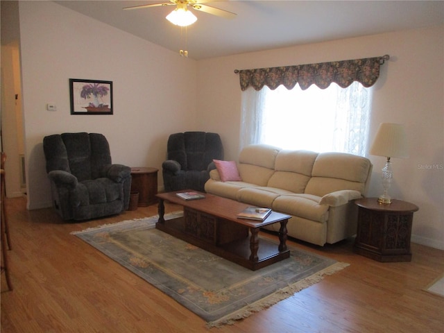 living room with a ceiling fan, lofted ceiling, and wood finished floors