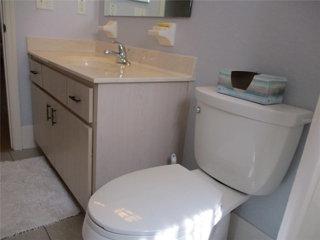 bathroom featuring tile patterned flooring, toilet, and vanity