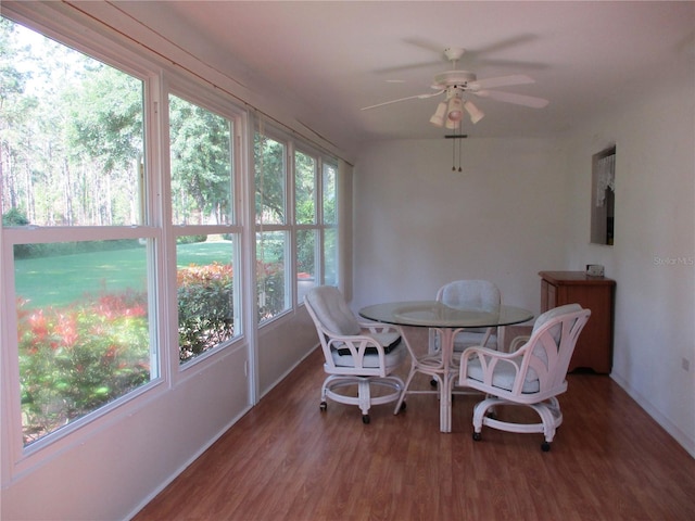 sunroom / solarium featuring baseboards and wood finished floors