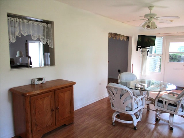 dining area with baseboards, a ceiling fan, and wood finished floors