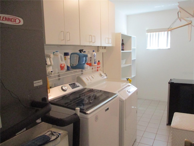 washroom featuring washing machine and clothes dryer, light tile patterned flooring, and cabinet space