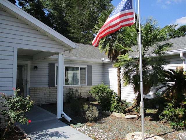 entrance to property featuring a shingled roof