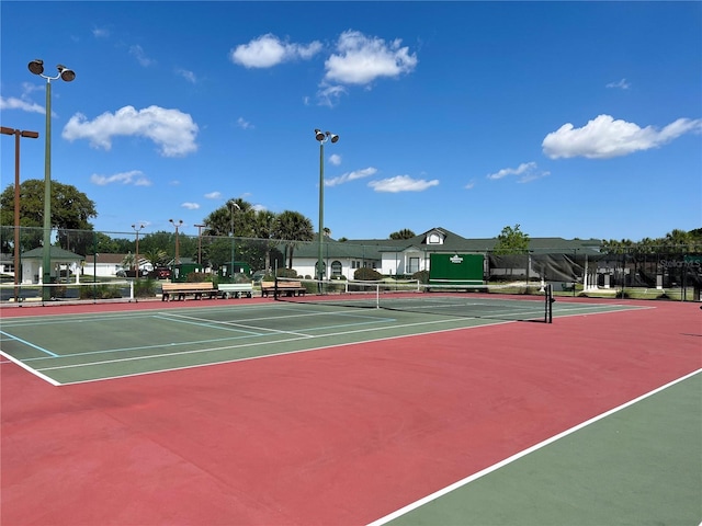 view of tennis court featuring fence and community basketball court