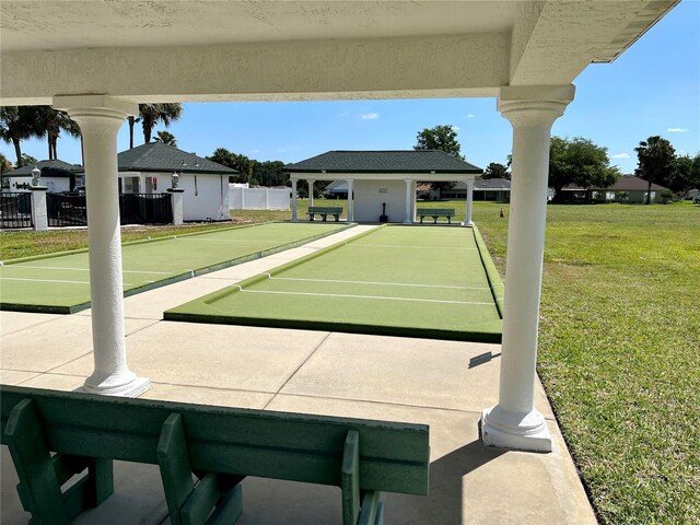 view of community with a lawn and fence