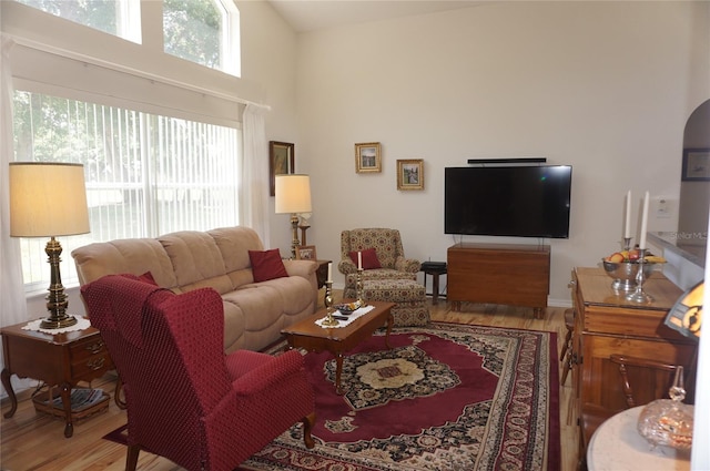 living area with a high ceiling and light wood-style floors
