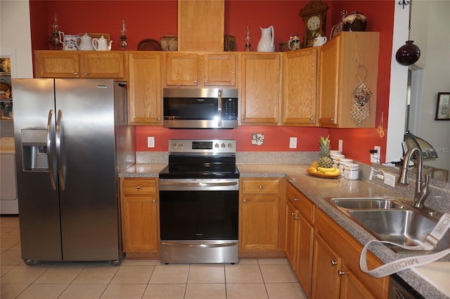 kitchen featuring light countertops, light tile patterned floors, appliances with stainless steel finishes, and a sink