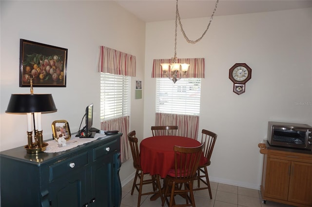dining area with an inviting chandelier, baseboards, light tile patterned floors, and a toaster