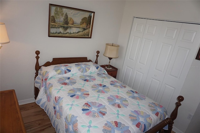 bedroom featuring baseboards, a closet, and wood finished floors
