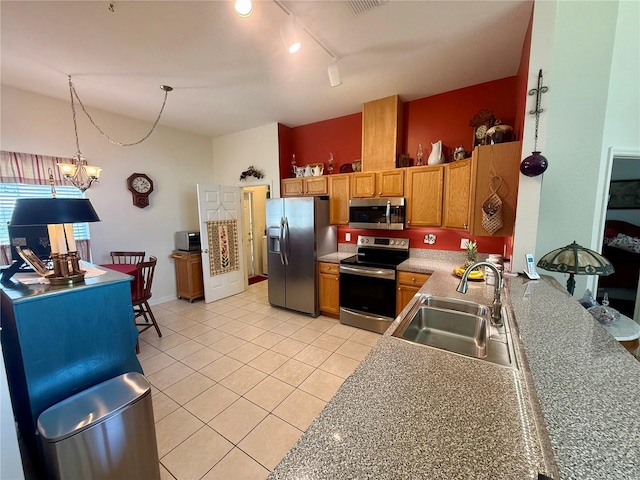 kitchen featuring brown cabinets, a sink, stainless steel appliances, decorative light fixtures, and light tile patterned floors