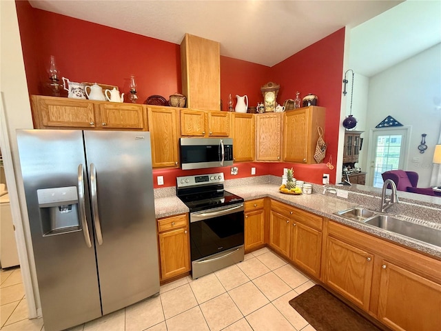 kitchen featuring brown cabinetry, light countertops, a sink, appliances with stainless steel finishes, and light tile patterned floors