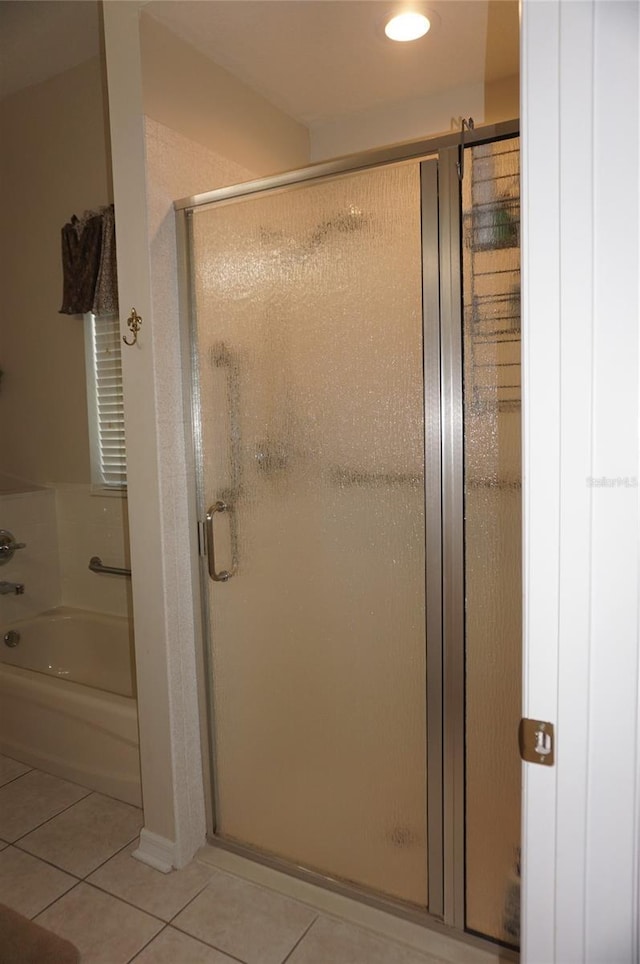 full bathroom featuring tile patterned flooring, a shower stall, and a garden tub