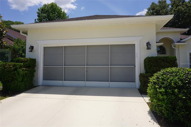 garage featuring concrete driveway