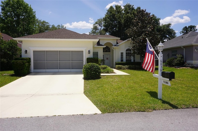 ranch-style home featuring a garage, stucco siding, driveway, and a front yard