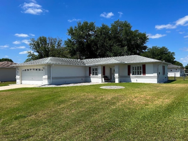 ranch-style home featuring a front yard, an attached garage, concrete driveway, and stucco siding