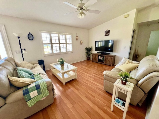 living area with ceiling fan, light wood-style floors, vaulted ceiling, and baseboards