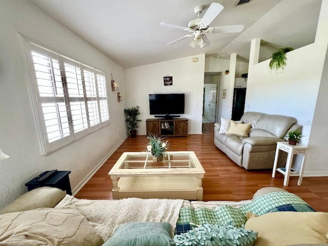 living area with wood finished floors, ceiling fan, vaulted ceiling, and baseboards